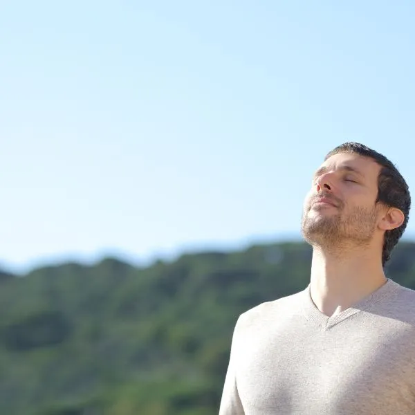 Homme respirant profondément en pleine nature pour s'apaiser